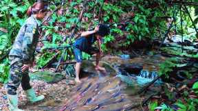 girl and boy catching fish cooking in the forest.